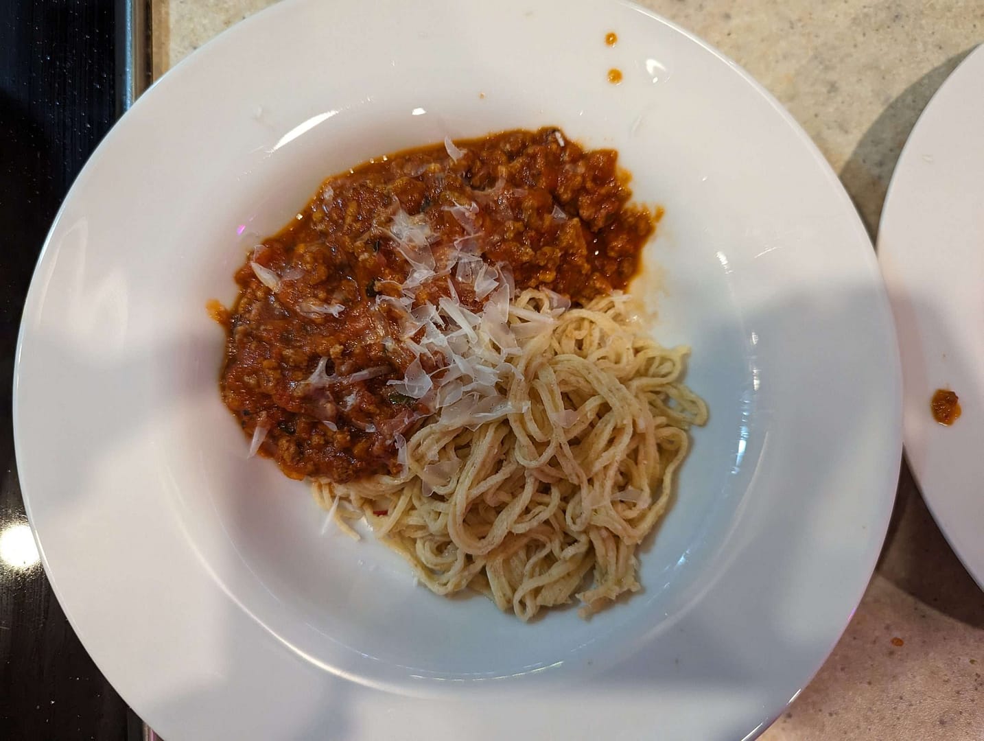 A plate of spaghetti and meat sauce being cooked on a stove.